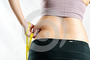 Fat woman, fat belly, chubby, obese woman hand pinching on her excessive belly fat waist with measure tape, woman diet lifestyle