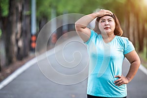 Fat woman feeling tired while running in the park