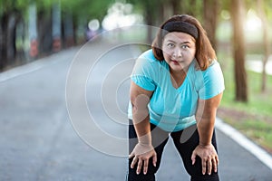 Fat woman feeling tired while running in the park