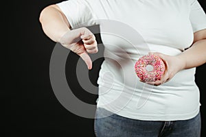 Fat woman fighting the temptation to eat junk food