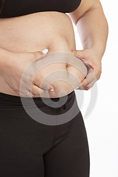 A fat woman grabs her belly with her hands, close-up