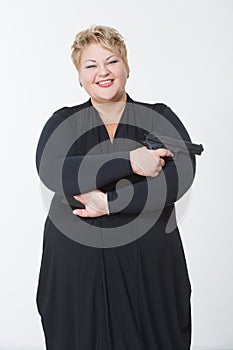 Fat woman with a gun. in a black dress