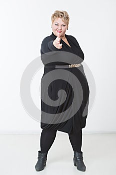 Fat woman with a gun. in a black dress