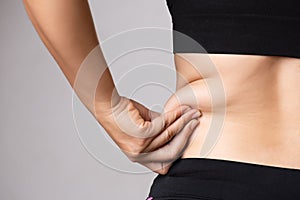 Fat woman hand holding excessive belly fat. Healthcare and woman diet lifestyle concept to reduce belly and shape up healthy