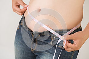 Fat woman hand measuring waist with white measuring tape