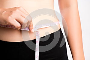 Fat woman hand measuring waist with white measuring tape, reducing excess weight. Healthcare and sport concept