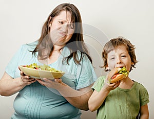 Fat woman holding salad and little cute boy with