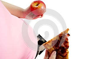 Fat woman holds an apple and pizza