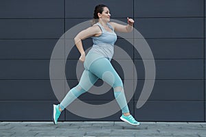 Fat woman jogging, doing sports for weight loss, obesity problem.
