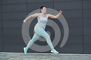 Fat woman jogging, doing sports for weight loss, obesity problem.