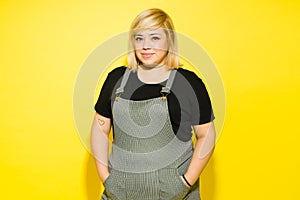 Fat woman looking confident in a studio on a yellow background