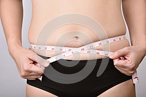 Fat woman measuring her belly fat, Overweight woman check out her obesity