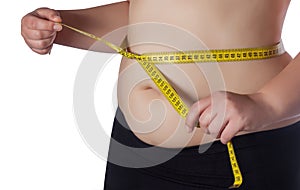 Fat woman measuring her waist with a yellow measuring tape.