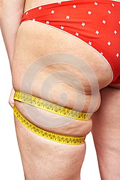 Fat woman measuring thigh leg tape measure