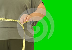 Fat woman is measuring the width of her waist