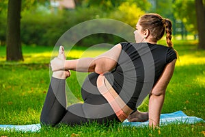 fat woman in the park doing yoga, plus size woman is very flexible