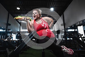 Fat woman shoeing hot dog like a dumbbell