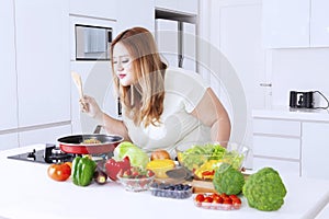 Fat woman sniffing meal on frying pan