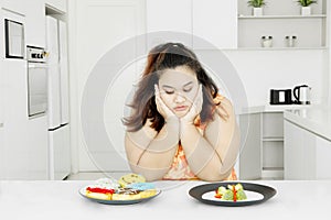 Fat woman with vegetable salad and donuts