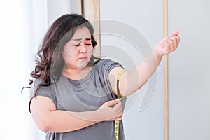 Fat women are sad because of the increase in size after checking with a tape measure