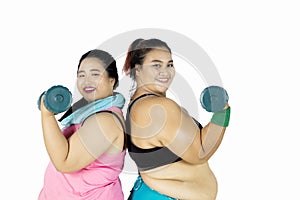Fat women showing their muscles on studio