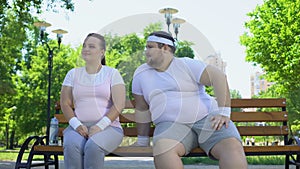 Fat young man acquainting with pretty obese lady sitting in park, confidence