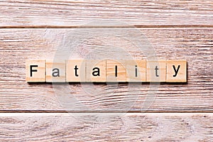 Fatality word written on wood block. fatality text on wooden table for your desing, coronavirus concept top view