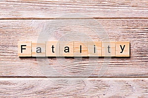 Fatality word written on wood block. fatality text on wooden table for your desing, coronavirus concept top view photo