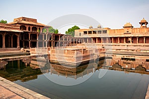 Fatehpur Sikri with a lot of columns located in Uttar Pradesh, India reflected in a pool