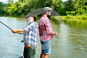 Father and adult son fishing in lake. Family time. Man bearded fisher. Fishing team. Big game fishing. Retired bearded