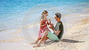 Father applying sun cream to daughter nose.