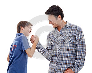 Father, arm wrestle and child with strength for game of power or playful bonding on a white studio background. Dad, son photo