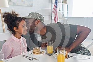 Father army uniform kissing african american daughter