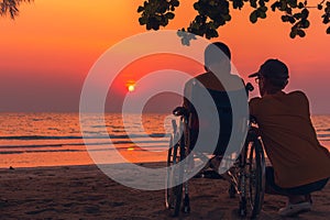 Father and Asian special child on wheelchair happy holiday time on sea beach at sunset
