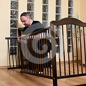 Father assembles new crib