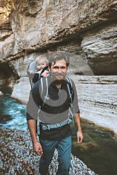 Father and baby in backpack carrier traveling hiking