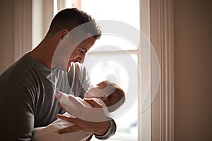 Father, baby and bonding with love and pride, growth and child development with happiness at family home. Man, infant or