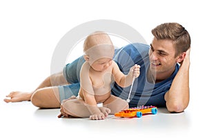 Father and baby boy having fun with musical toys. Isolated on white background
