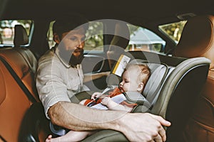 Father and baby in car child sitting in safety seat