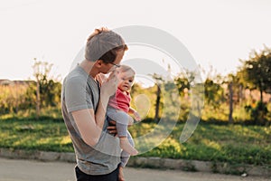 Father and baby daughter outside in the sunset