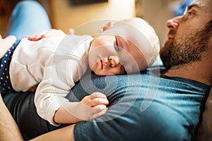 Father with a baby girl at home sleeping.