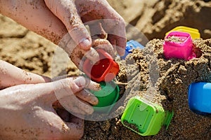 Father and baby hands playing with sand at the beach