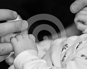 A father and baby hold hands