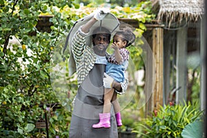 Father with beard holding his Daughter in his arms looking at him with love in rainy. Happy loving father holding daughter and lau