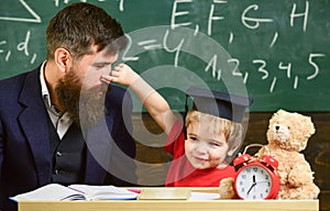 Father with beard, teacher teaches son, little boy, while child pinching his nose. Kid cheerful play with dad. Playful