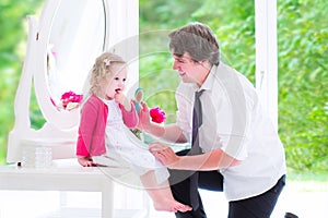 Father brushing his daughter hair