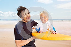 Father carry son play with surfboard on the beach