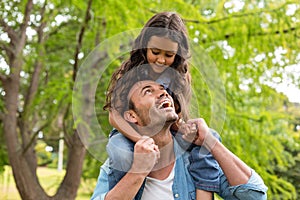 Father carrying daughter on his shoulders