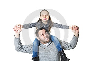 Father carrying daughter on his shoulders, studio shot