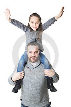 Father carrying daughter on his shoulders, studio shot